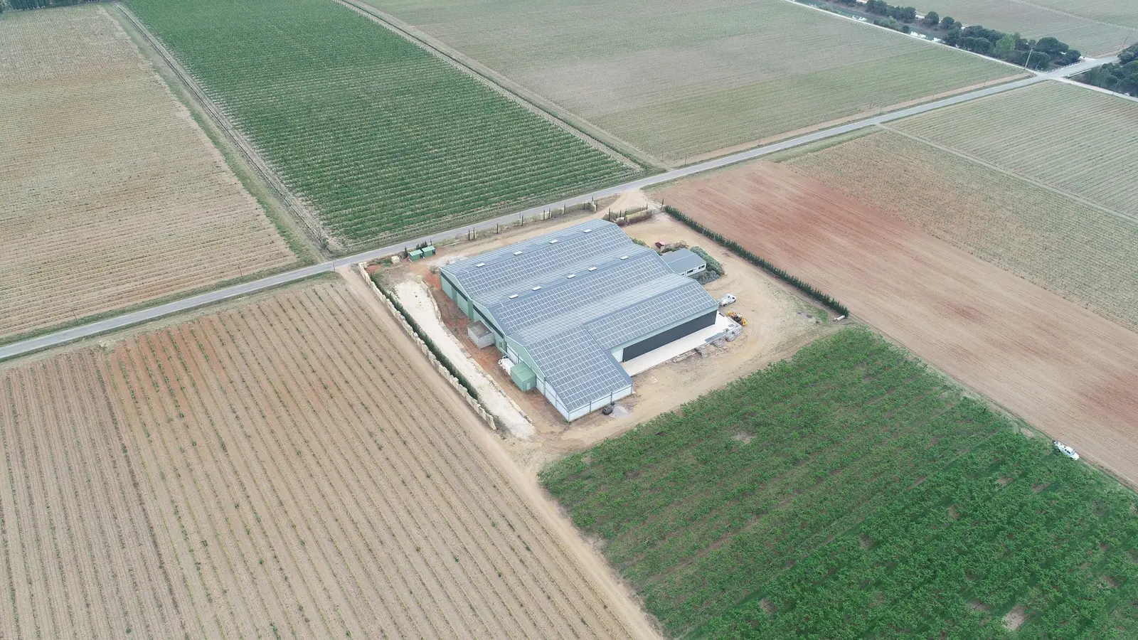 Hangar agricole photovoltaïque vu du ciel au milieu des champs